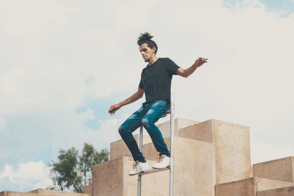 A stunt artist balancing on a ladder